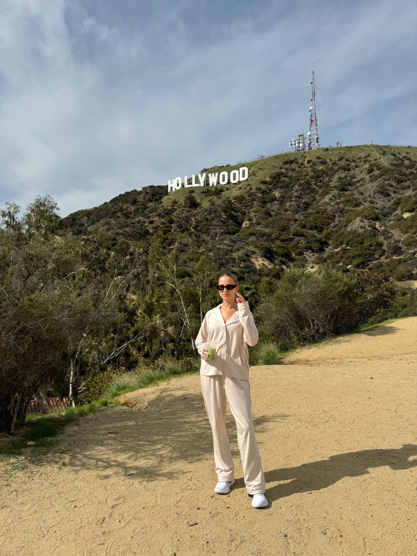 Creator in a cream Melowe set below the Hollywood sign